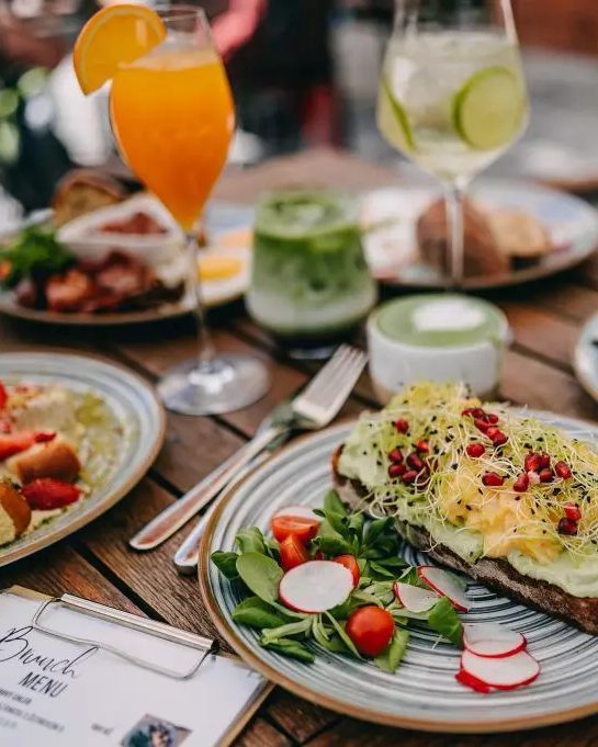 Brunchový stůl: toast s avokádem a klíčky, matcha, pomerančový drink a limonáda